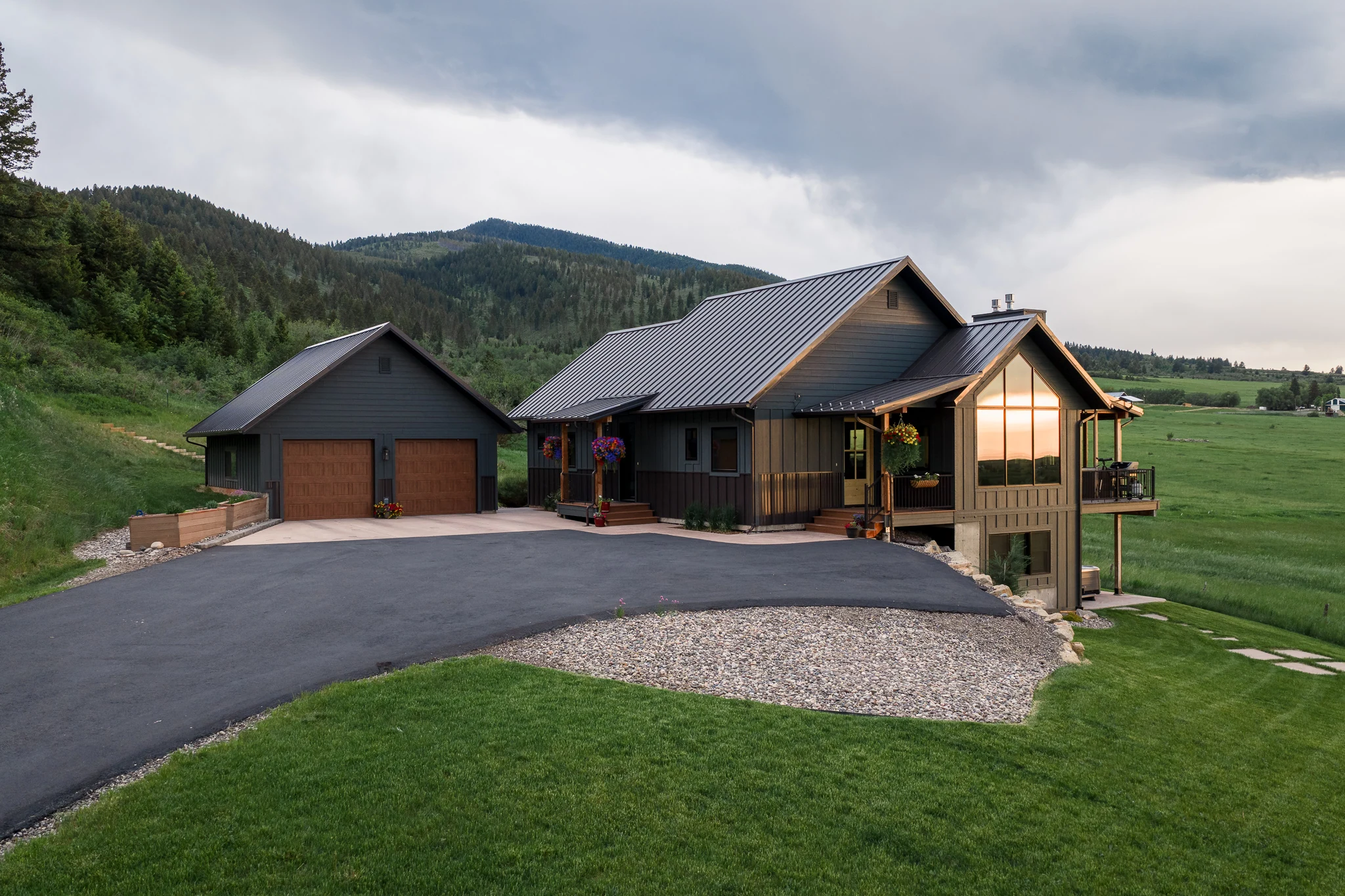 Aerial exterior view of the modern farmhouse home at dusk — architectural photography Livingston Montana, Sam Schlauch Designs